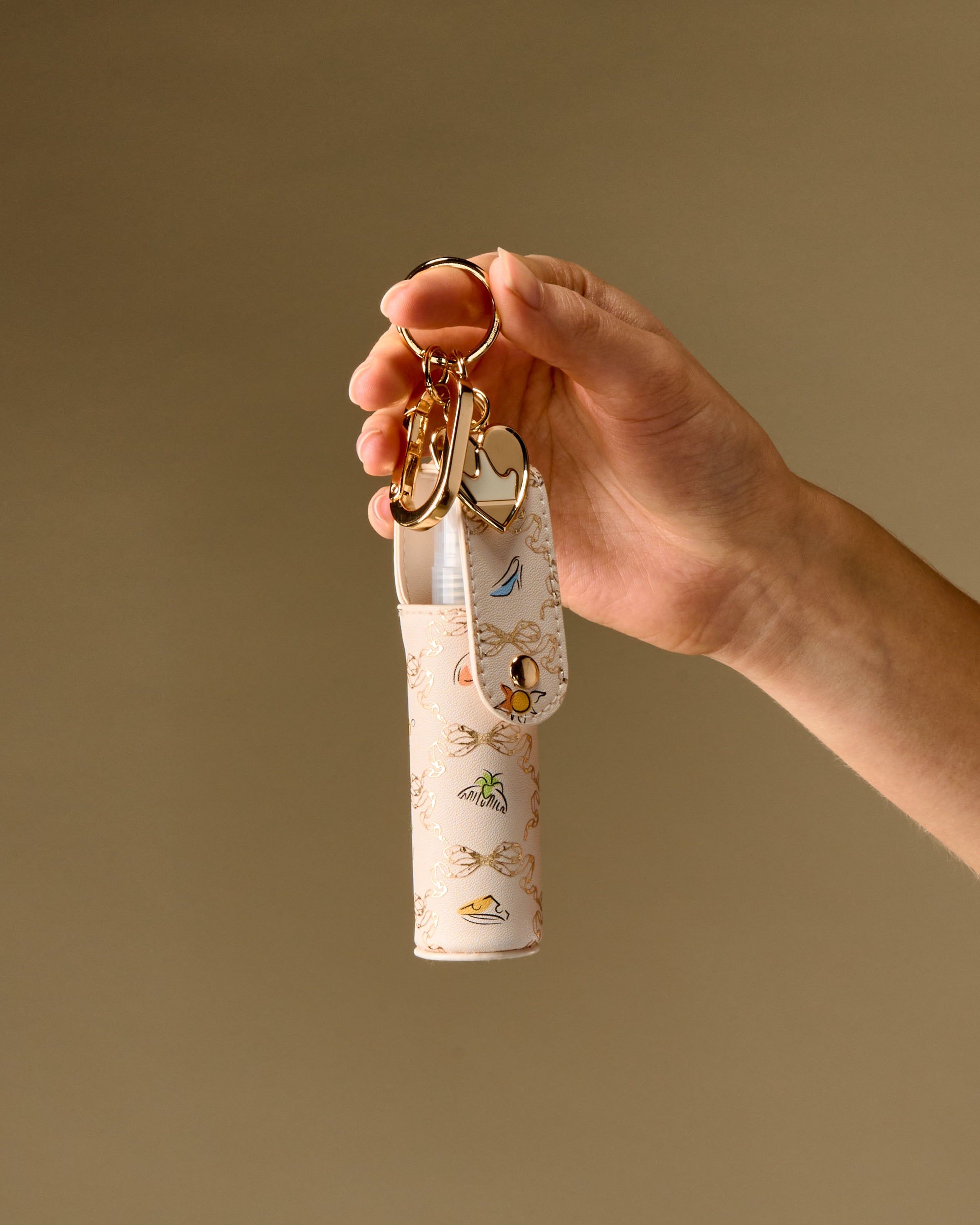 Etui na błyszczyk Bath & Body Works z kolorowym wzorem i złotymi zawieszkami.