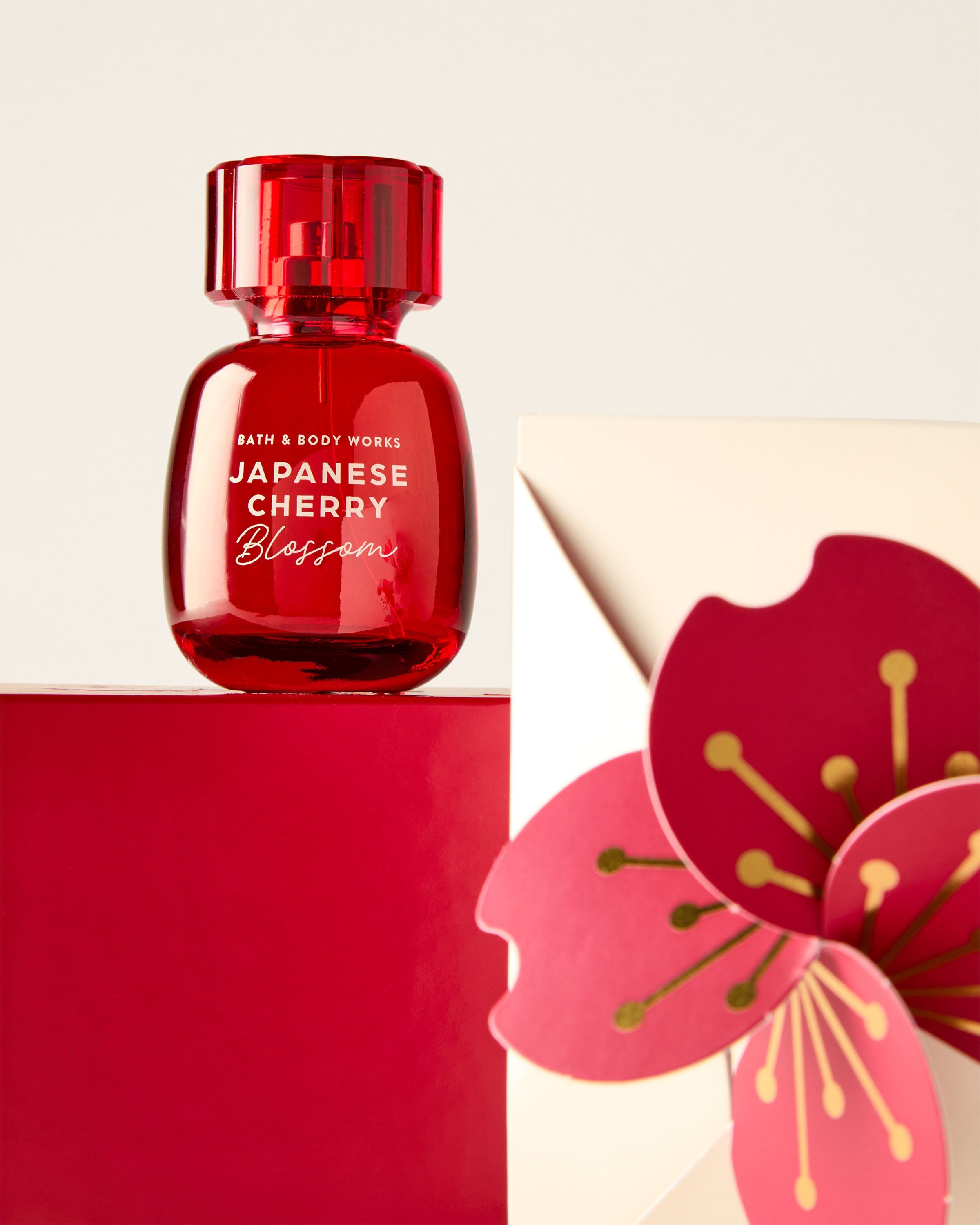 Czerwona woda perfumowana Bath & Body Works Japanese Cherry Blossom na czerwonej podstawie z motywem kwiatowym