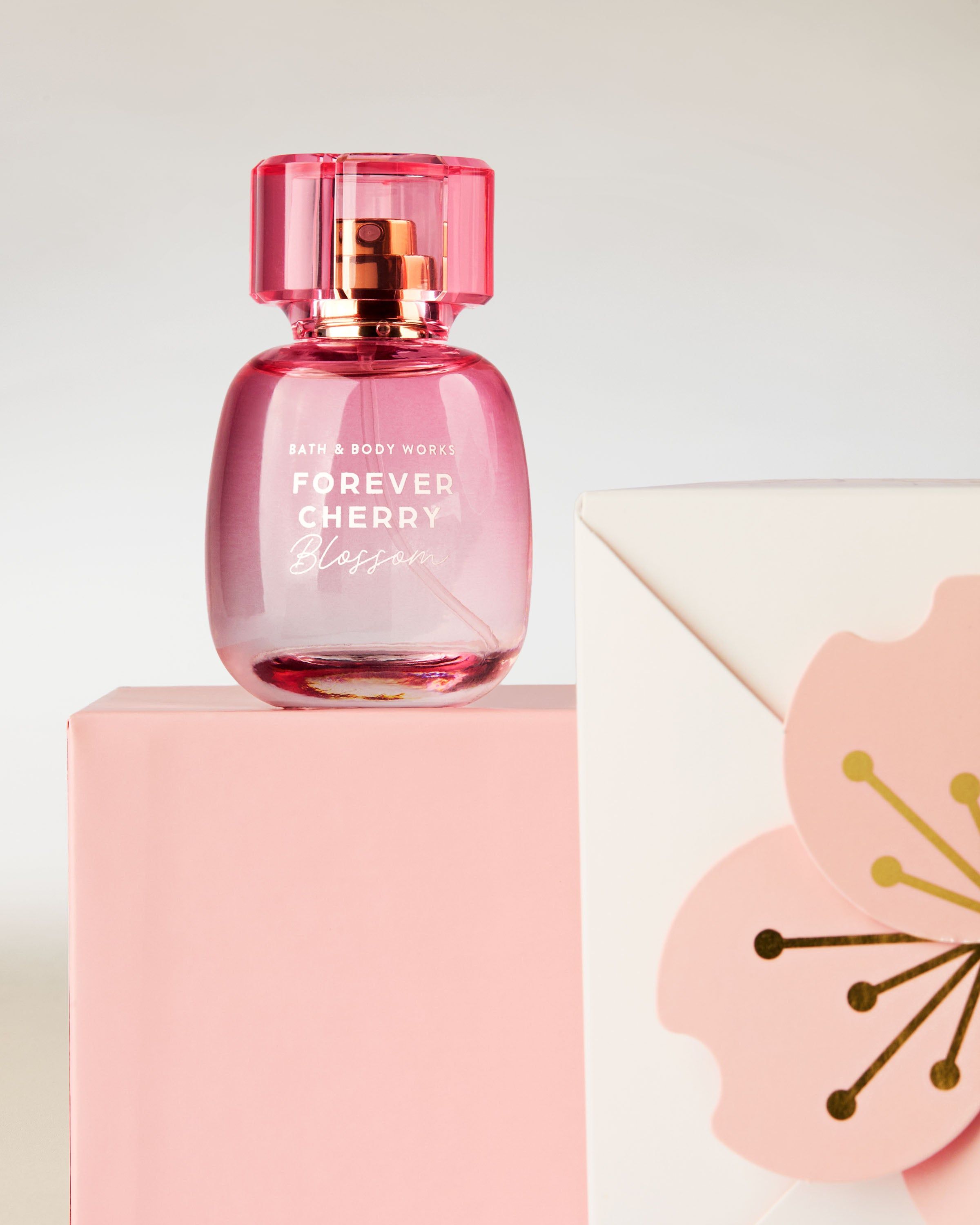 Perfumy Bath & Body Works Forever Cherry Blossom w różowym flakonie na tle kwiatów wiśni.