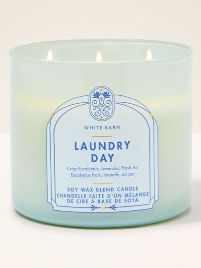 Płonąca świeca Laundry Day White Barn w jasnoniebieskim szklanym słoju z etykietą w niebieskiej ramce