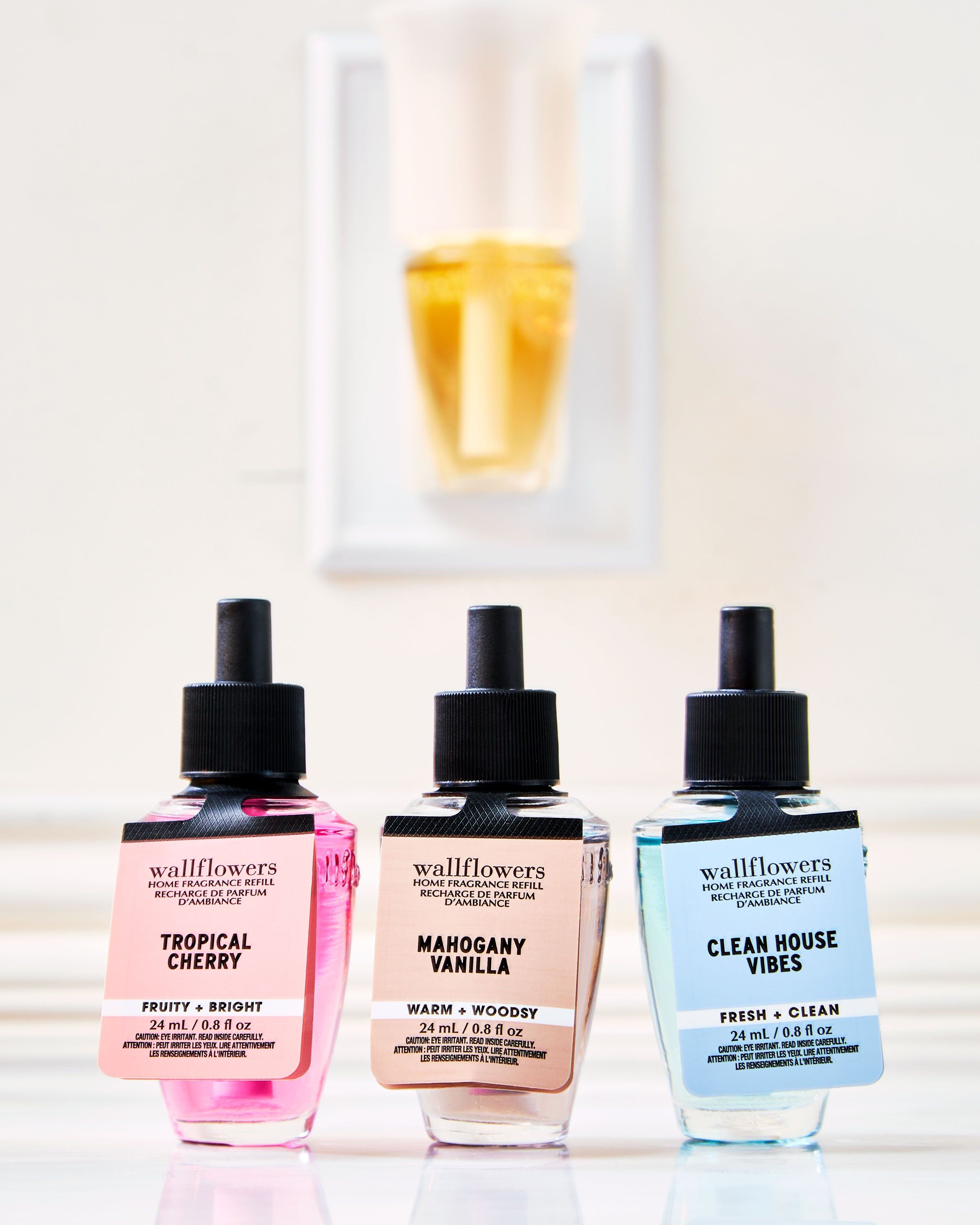Trio wkładów Wallflowers: Tropical Cherry, Mahogany Vanilla i Clean House Vibes przed odświeżaczem.