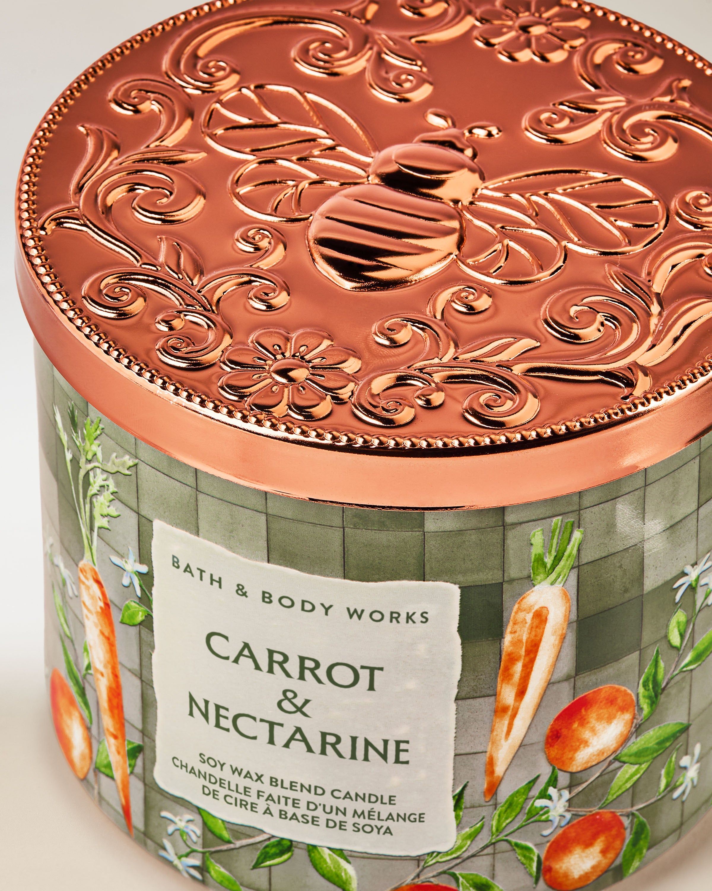 Świeca zapachowa 3‑knotowa Bath & Body Works Carrot & Nectarine w szklanym słoju z motywem marchwi i owoców.