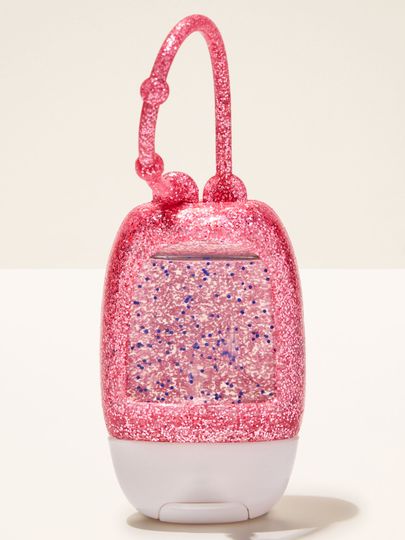 Brokatowy uchwyt PocketBac w intensywnym odcieniu różu, wykonany z elastycznego materiału, zaprojektowany do wygodnego przypięcia mini żelu antybakteryjnego.