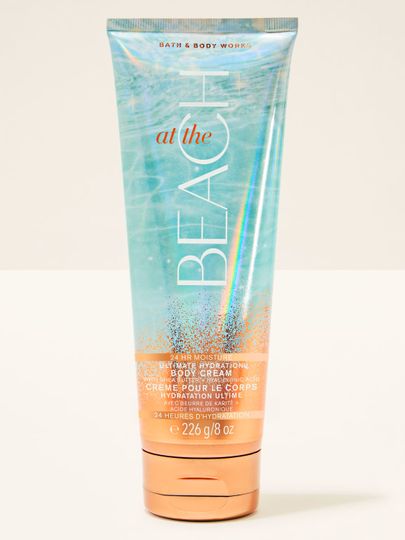 Krem do ciała Bath&Body Works At the Beach. Tubka w kolorze turkusowo-pomarańczowym z brokatem i napisami.