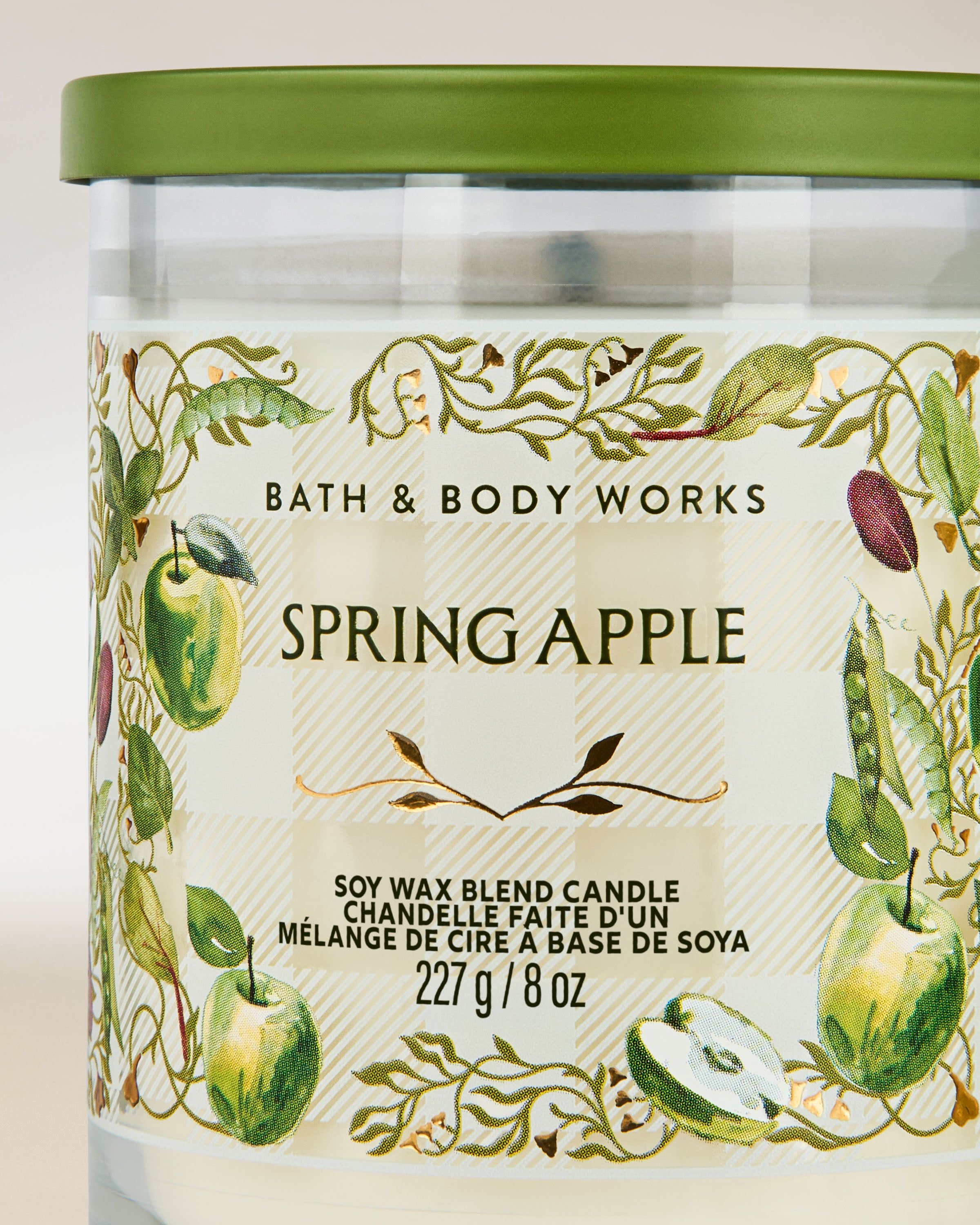Świeca zapachowa Bath & Body Works Spring Apple 227 g w przezroczystym szkle z motywem zielonych jabłek.