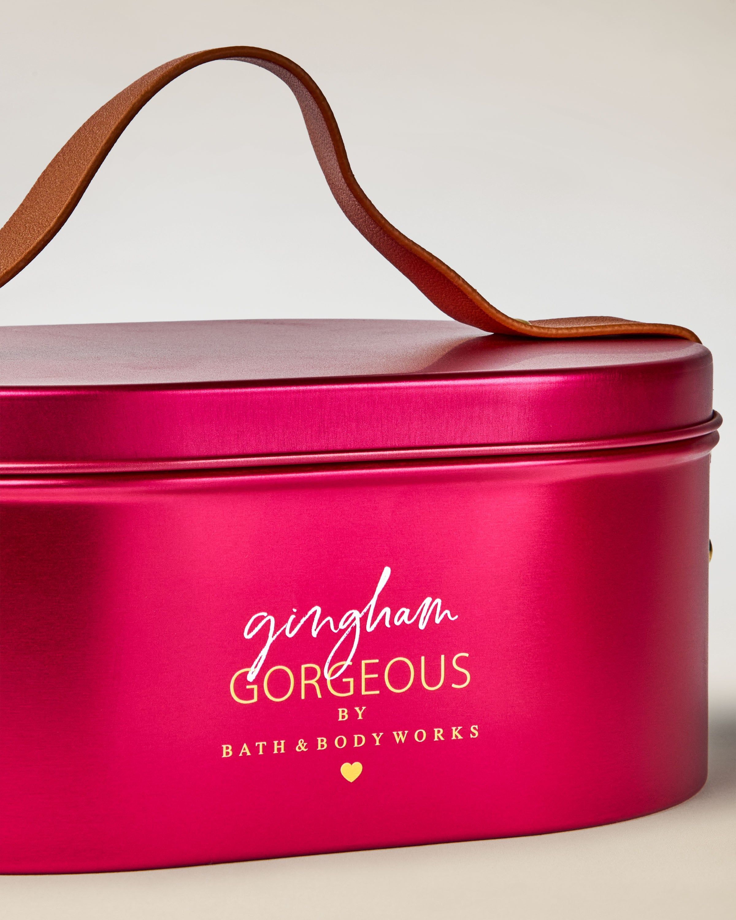 Flakon perfum Bath & Body Works Gingham Gorgeous w różowym szkle z dekoracyjną kokardą.