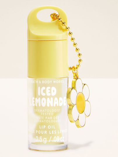 Olejek do ust Bath & Body Works Iced Lemonade 2,5 g w żółtym opakowaniu z brelokiem w kształcie kwiatu.