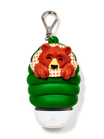 Etui na żel do rąk Bath&Body Works w kształcie misia w śpiworze. Zielone etui z brązowym misiem i metalowym karabińczykiem.