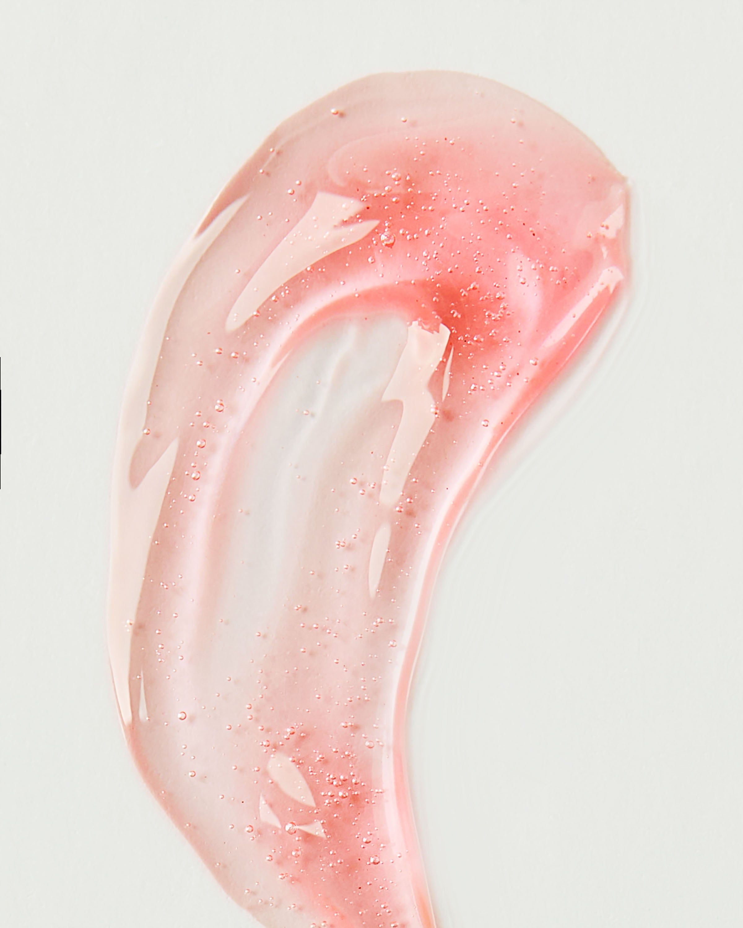 Olejek do ust Bath & Body Works Strawberry Glaze 2,5 g w różowym opakowaniu z brelokiem w kształcie truskawki.