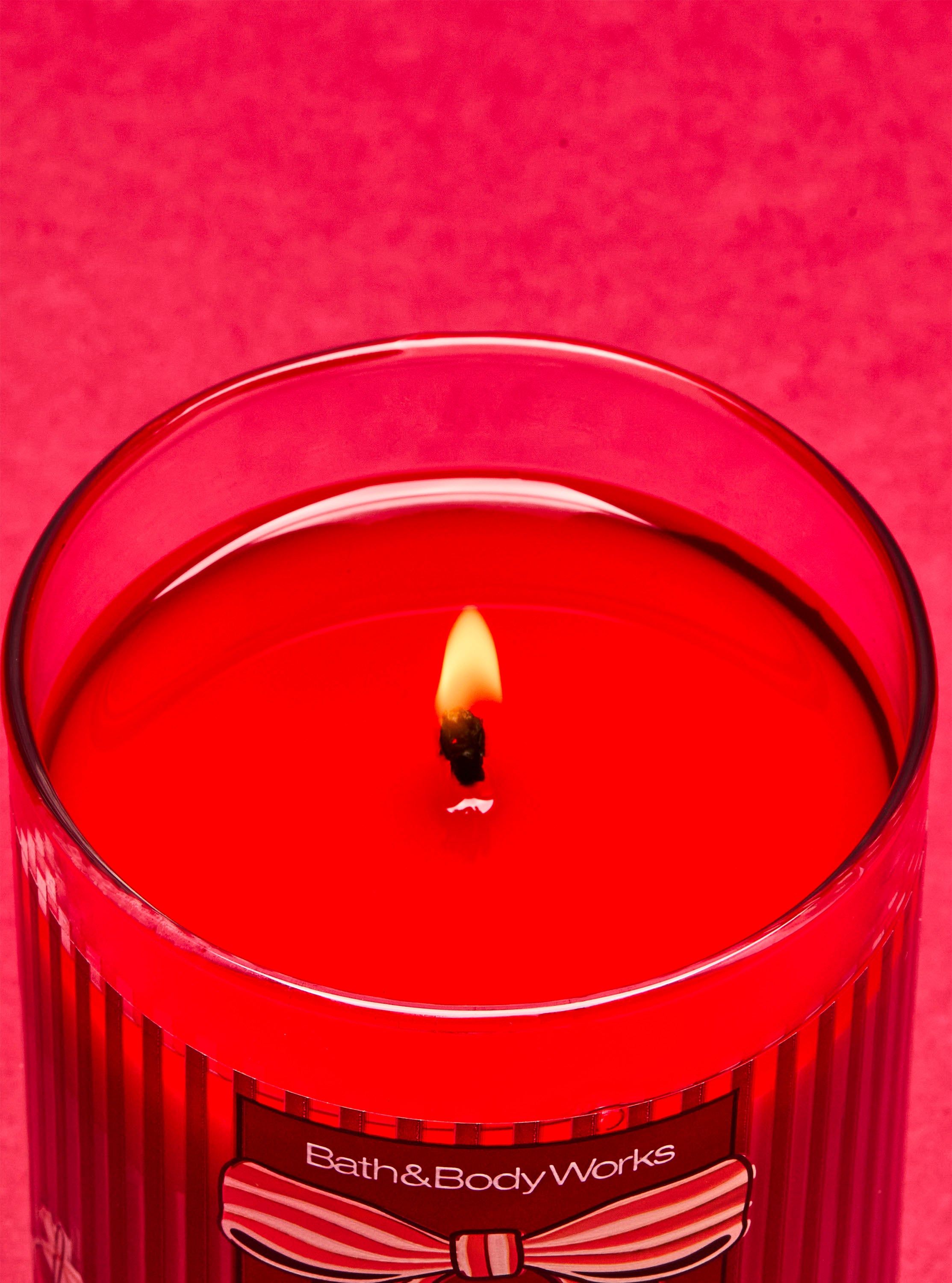 Świeca zapachowa Winter Candy Apple Bath & Body Works z jednym płonącym knotem i motywem karmelizowanego jabłka