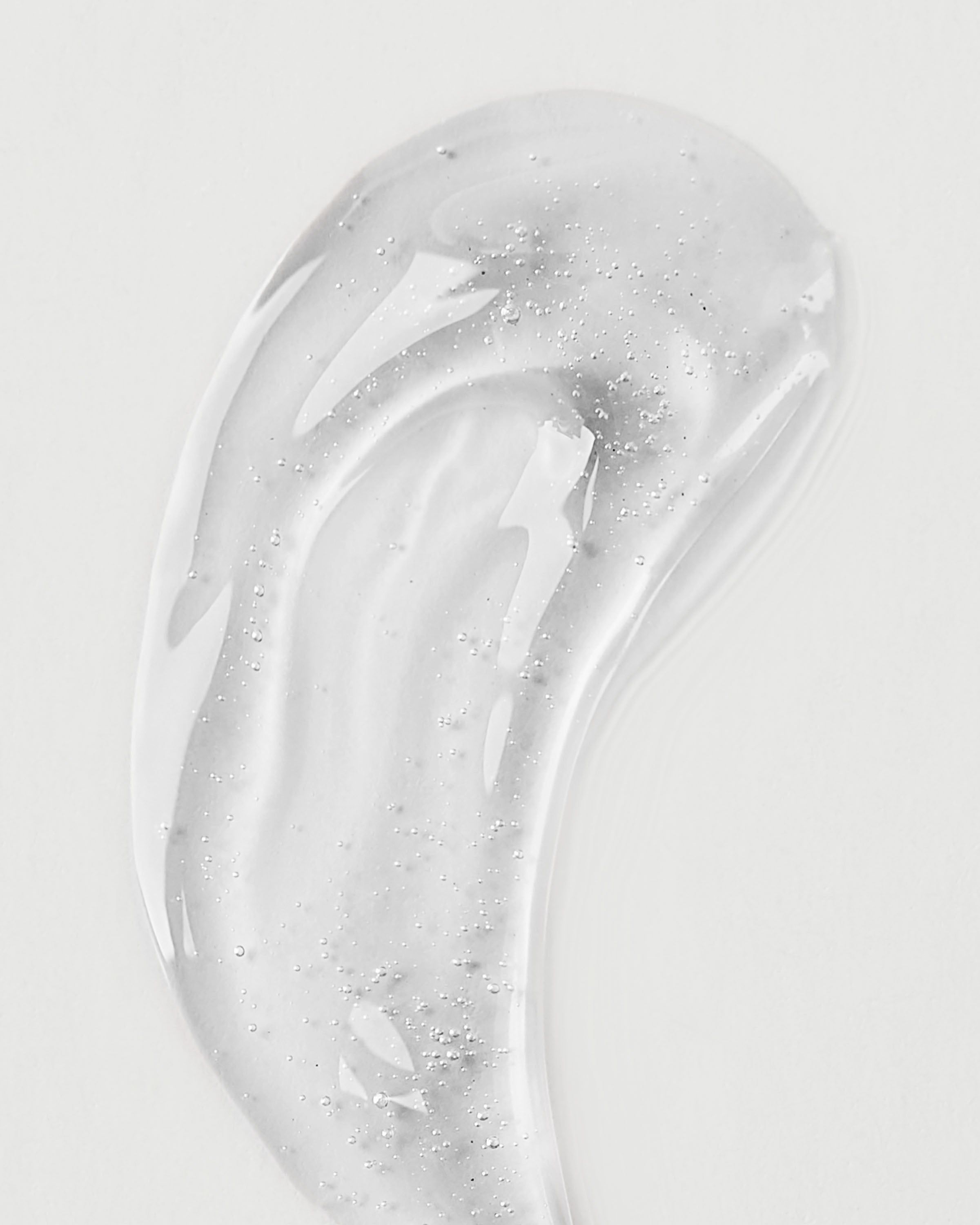 Olejek do ust Bath & Body Works Iced Lemonade 2,5 g w żółtym opakowaniu z brelokiem w kształcie kwiatu.