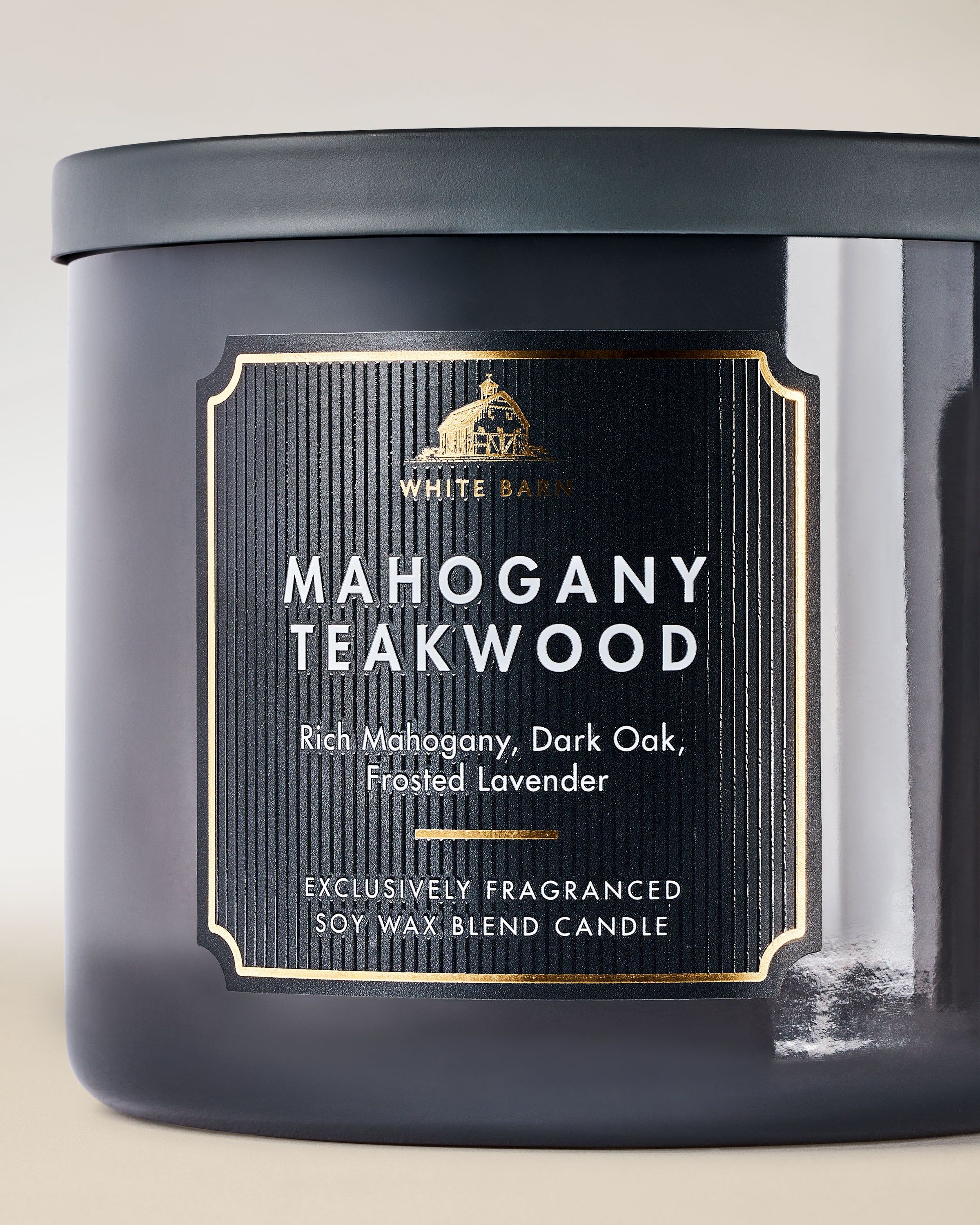 Świeca Mahogany Teakwood w eleganckim szklanym opakowaniu, z charakterystycznym aromatem drewna i subtelnymi akcentami kompozycji White Barn.