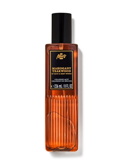 Mgiełka do ciała Bath&Body Works Mahogany Teakwood. Brązowa butelka z czarnym atomizerem, etykietą z napisami w złotym kolorze.