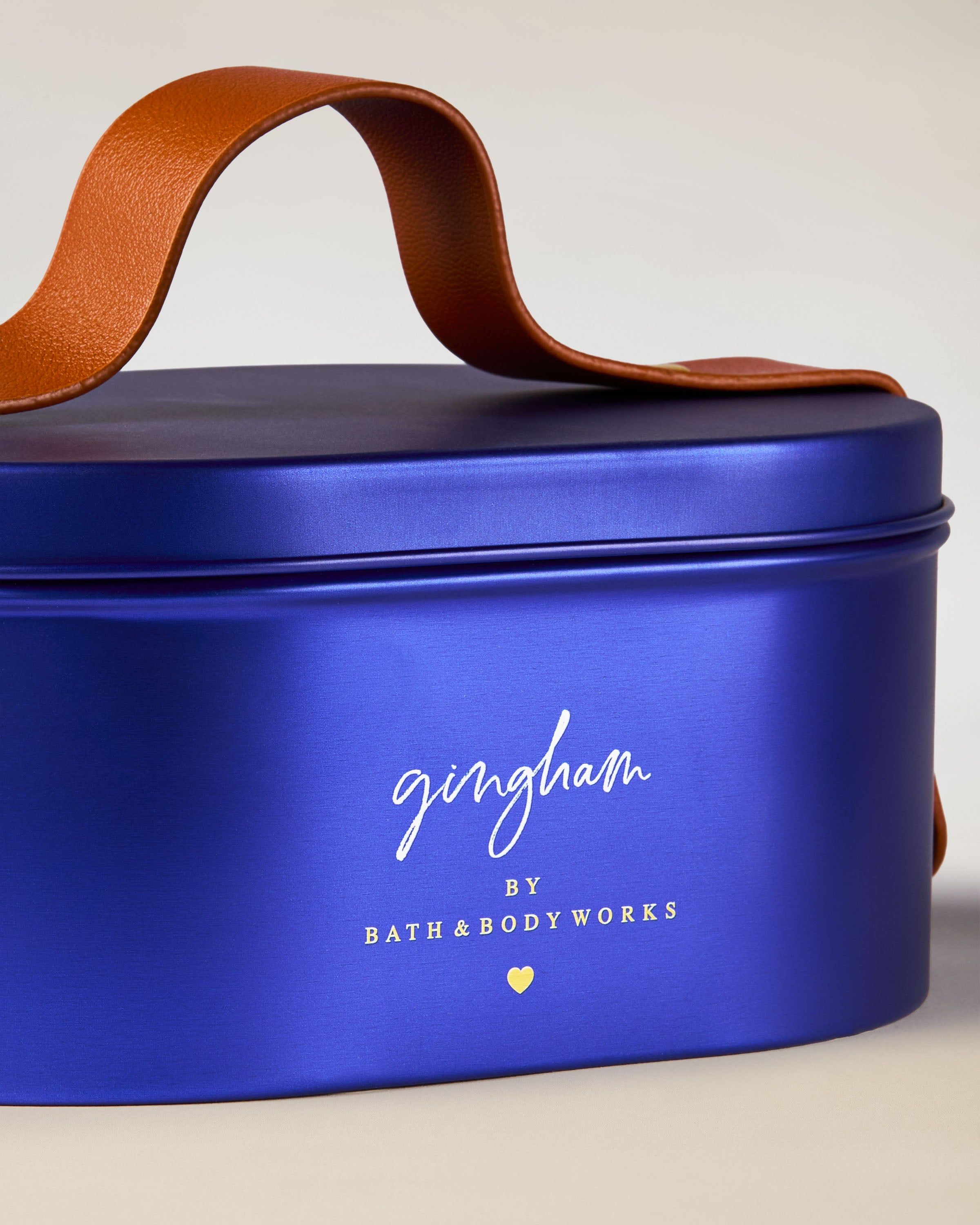 Perfumy Bath & Body Works Gingham w niebieskim szklanym flakonie z dekoracyjną kokardą.