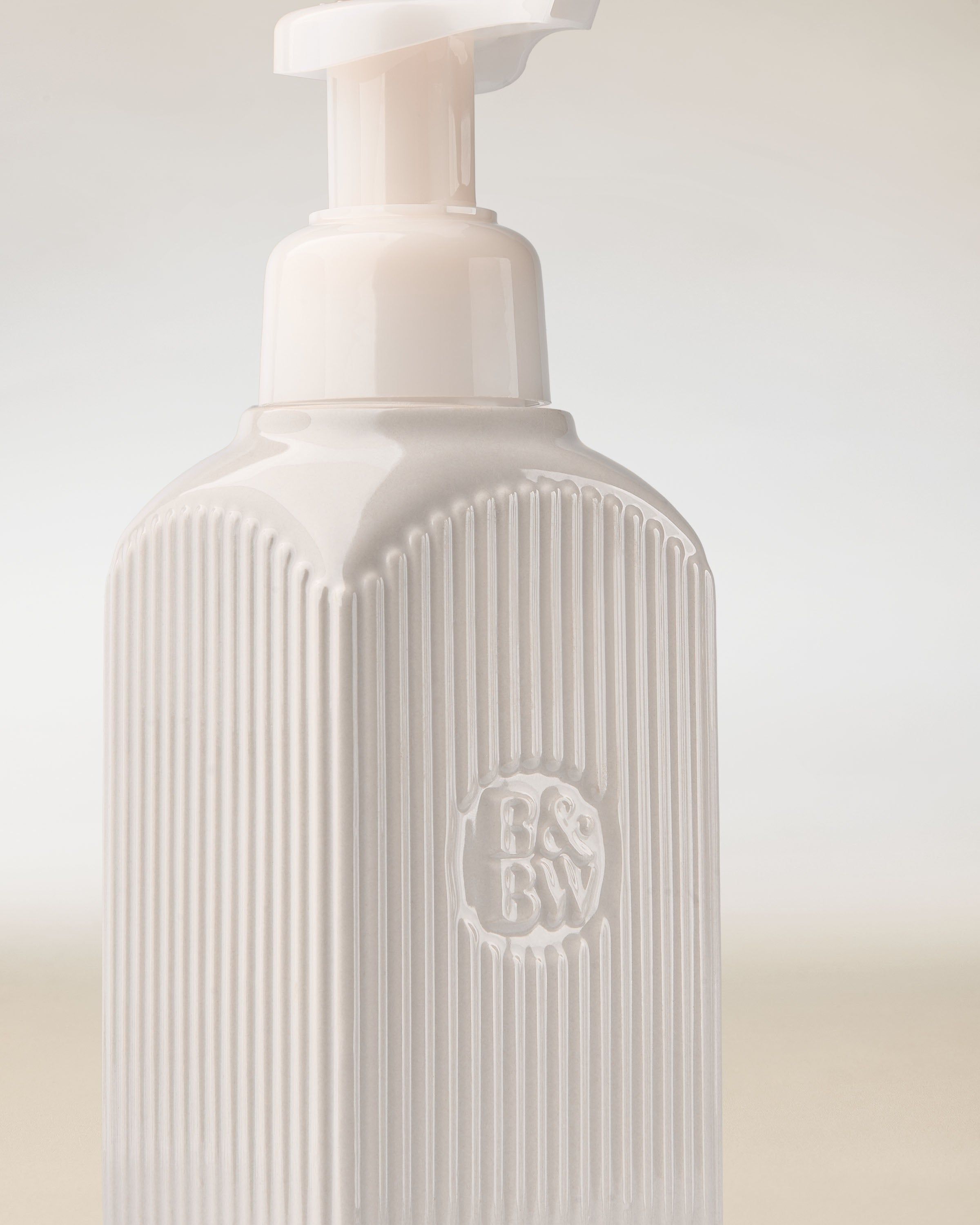 Dozownik na mydło Bath & Body Works w białym kolorze z pompką i tłoczonym logo.