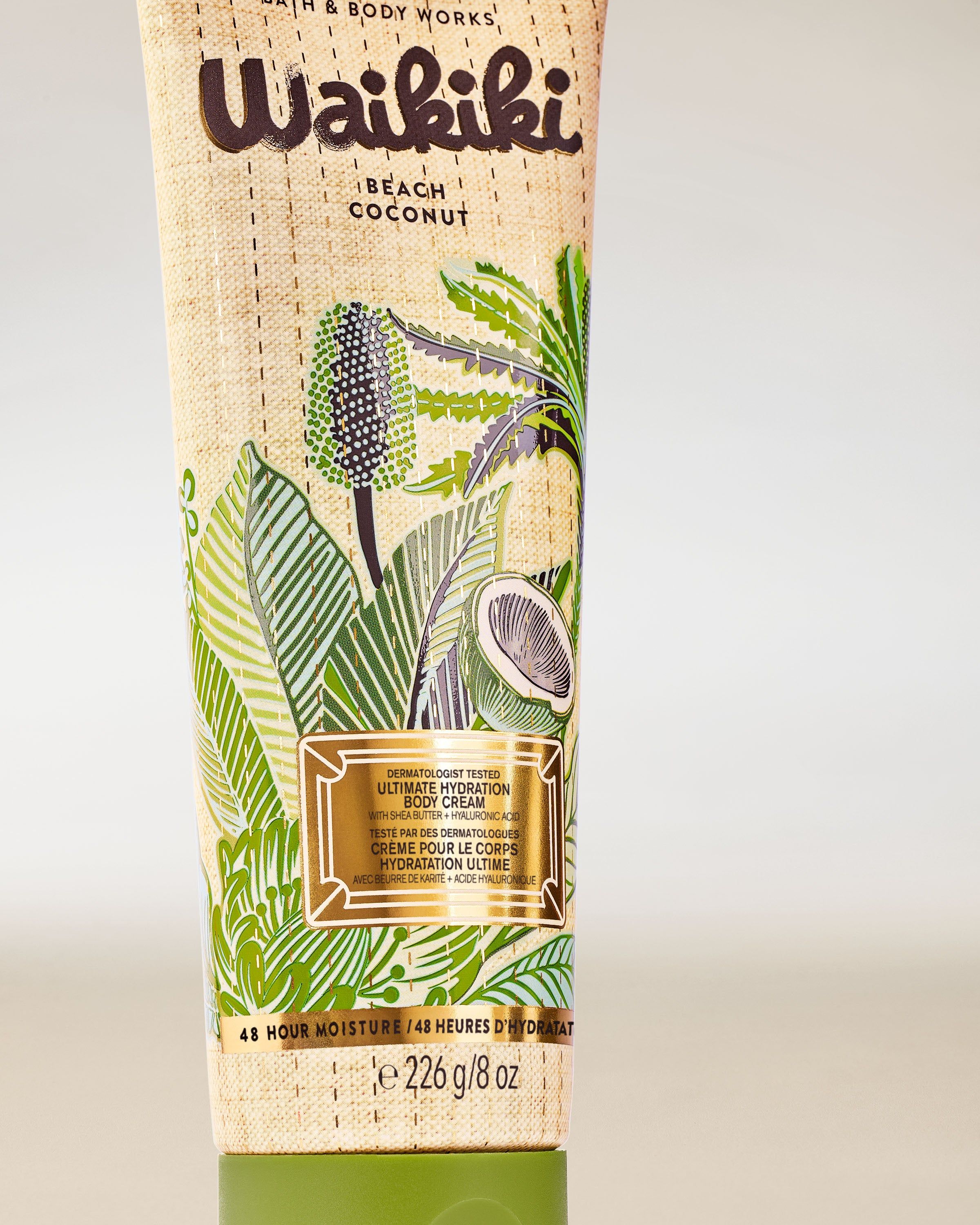 Krem do ciała Waikiki Beach Coconut w jasnej tubie z zielonymi palmami i kokosowym motywem na naturalnym tle.