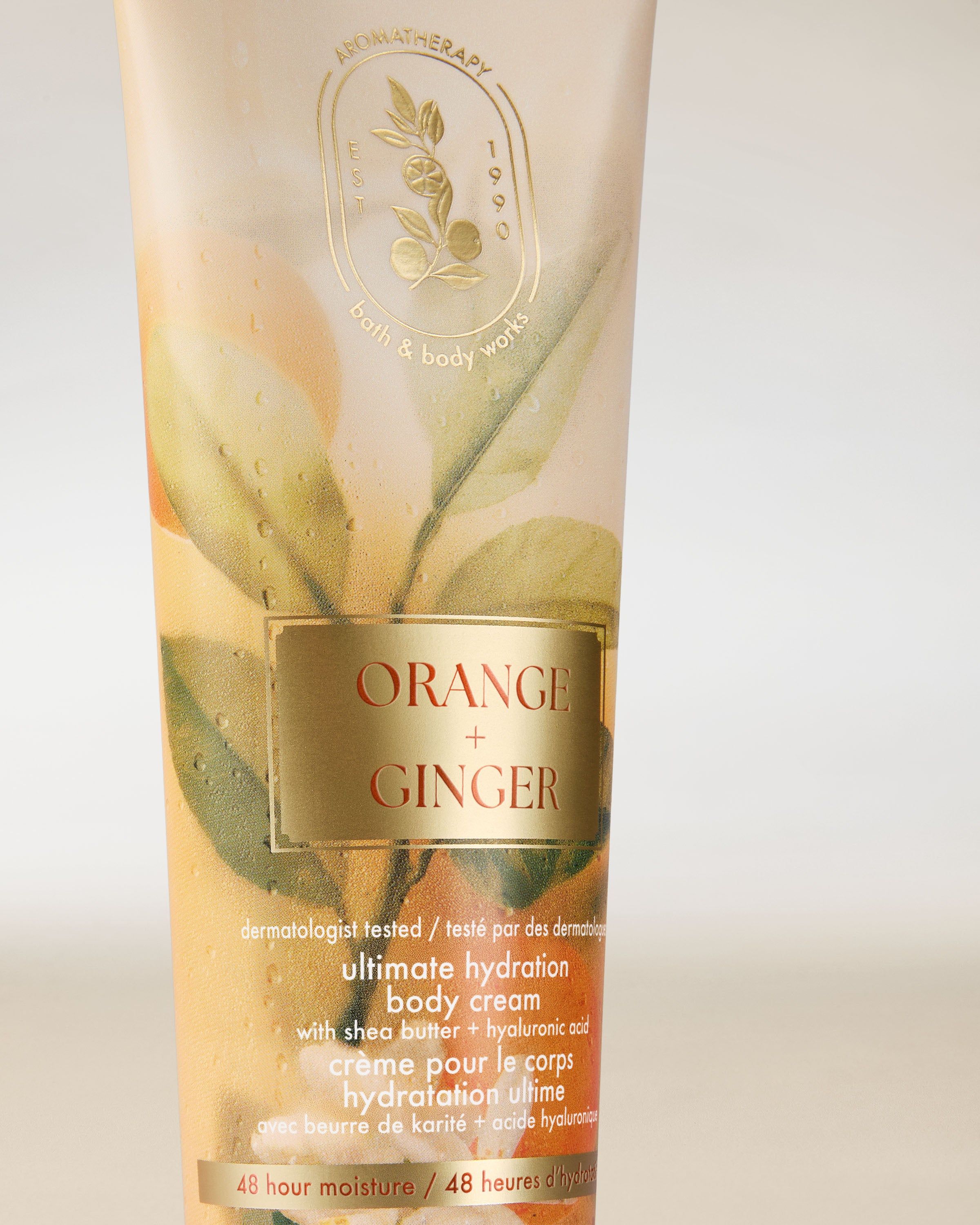 Krem do ciała Bath & Body Works Aromatherapy Orange + Ginger 226 g w jasnej tubie z roślinnym motywem.