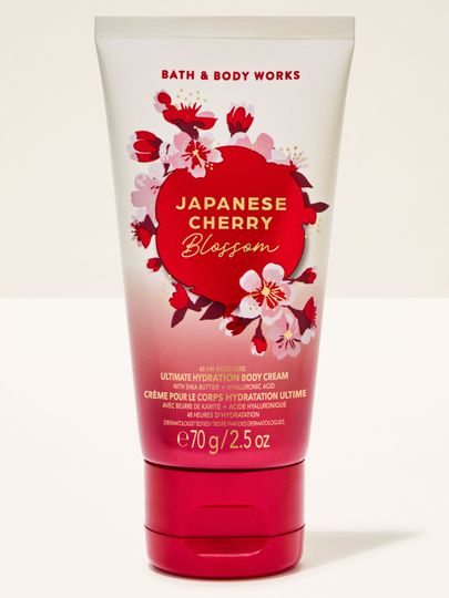 Krem do ciała Bath & Body Works "Japanese Cherry Blossom" w tubce z biało-czerwonym gradientem i kwiatami.