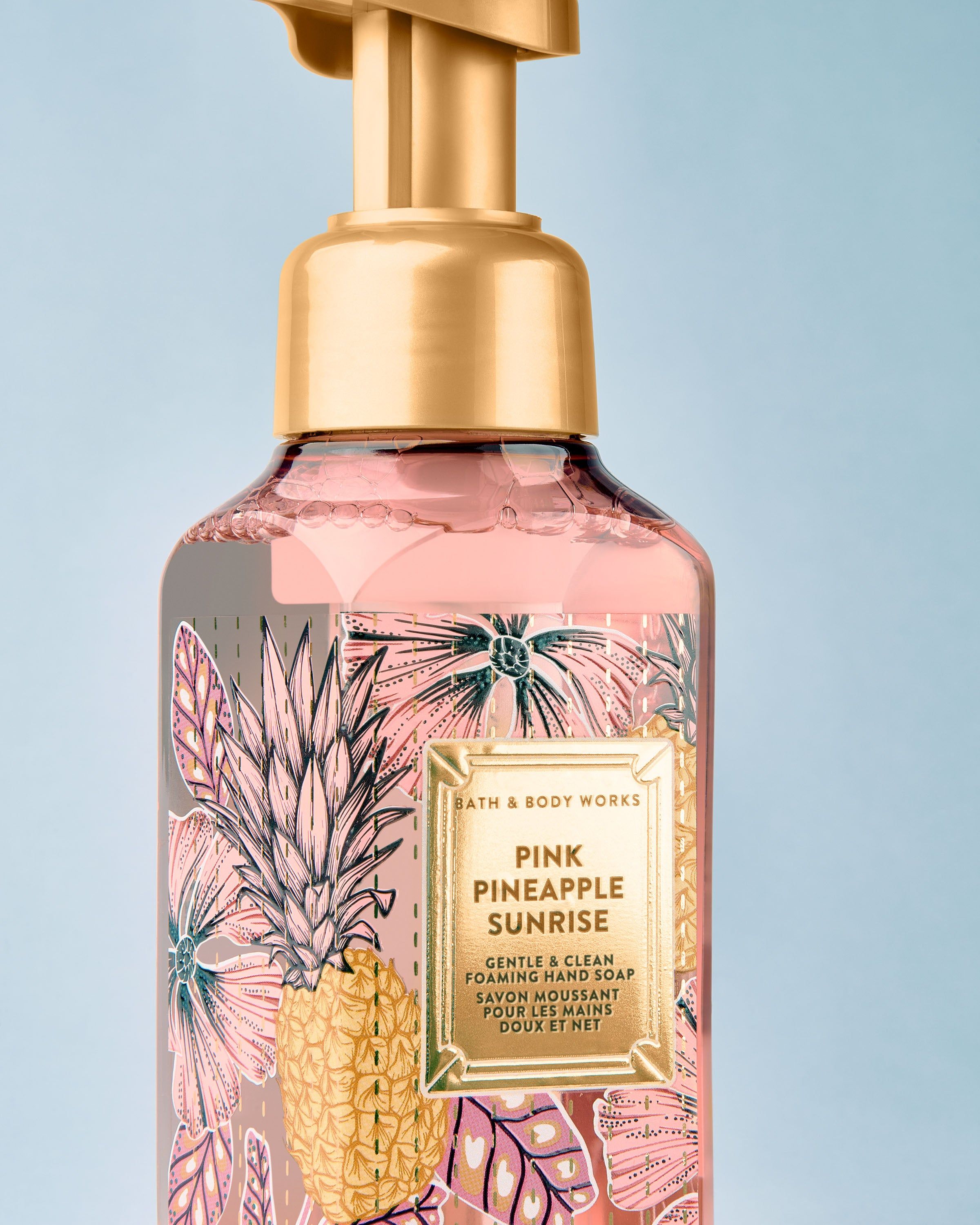 Pink Pineapple Sunrise – różowe mydło w piance z elegancką złotą pompką i tropikalną etykietą w ananasy.
