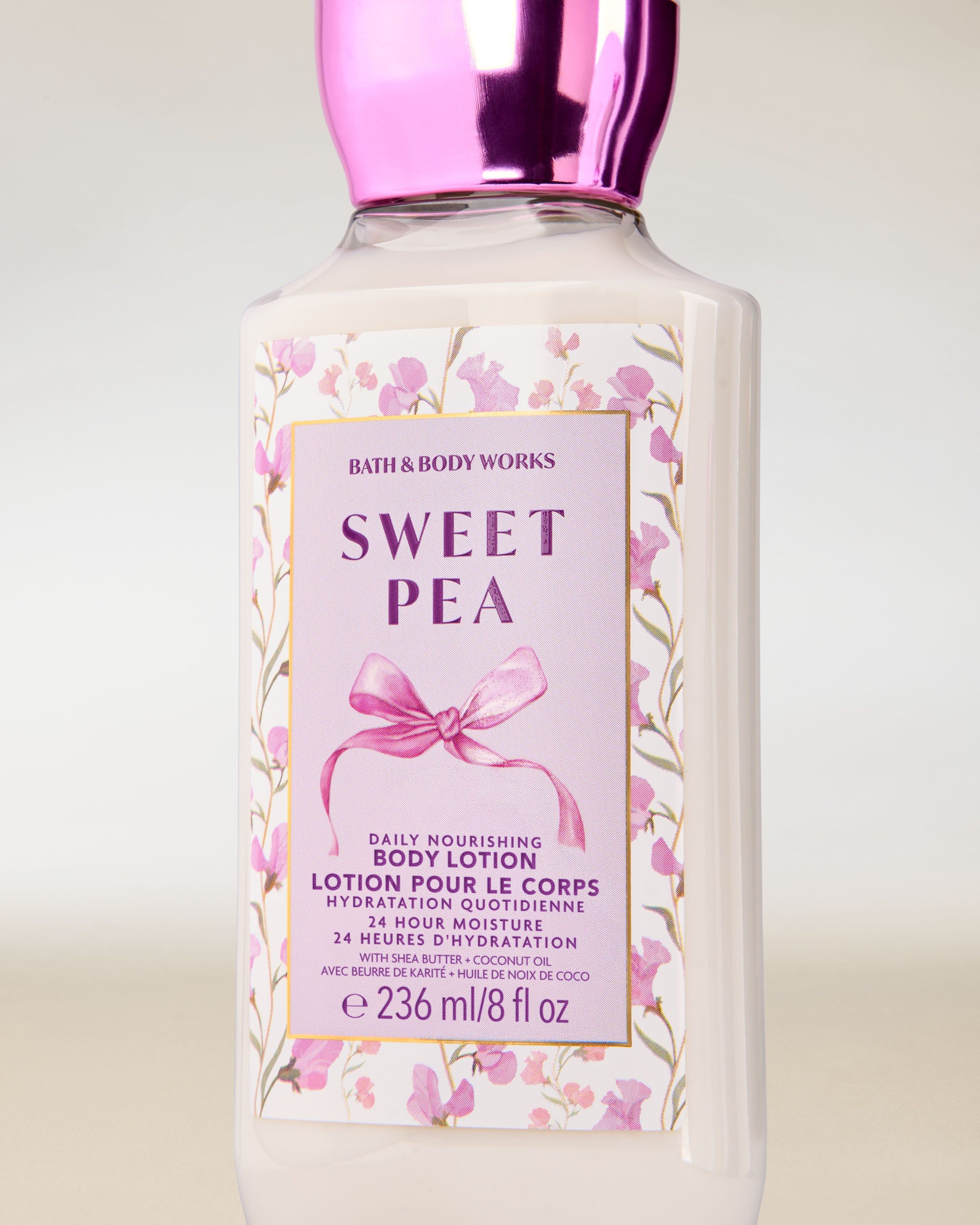 Balsam do ciała Bath & Body Works Sweet Pea 236 ml w jasnej butelce z kwiatową etykietą i różową zakrętką.