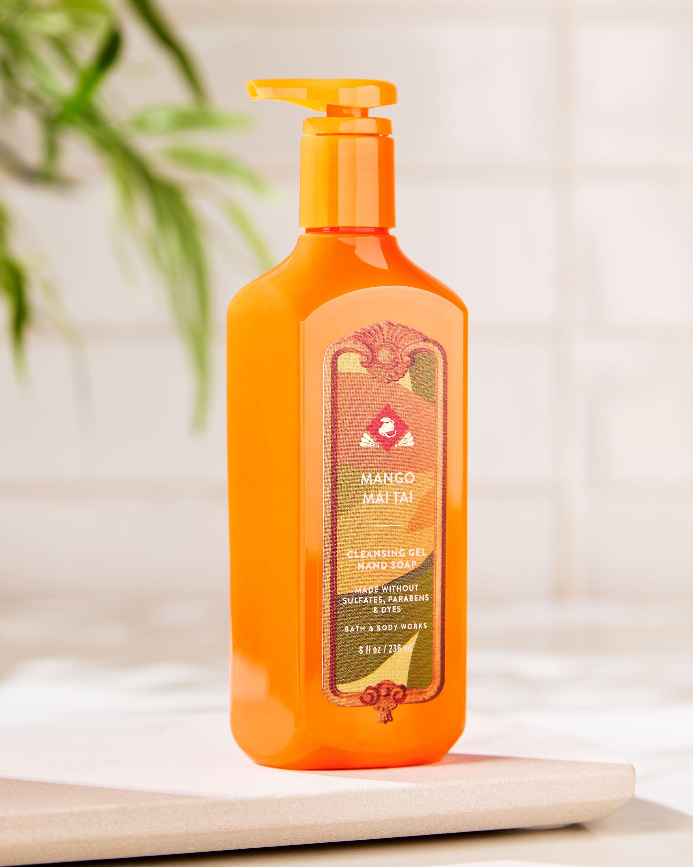 Mydło w żelu Bath & Body Works Mango Mai Tai w pomarańczowej butelce z tropikalną etykietą.
