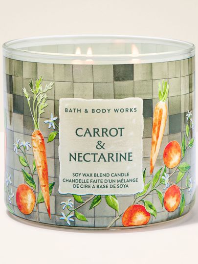 Świeca zapachowa 3‑knotowa Bath & Body Works Carrot & Nectarine w szklanym słoju z motywem marchwi i owoców.