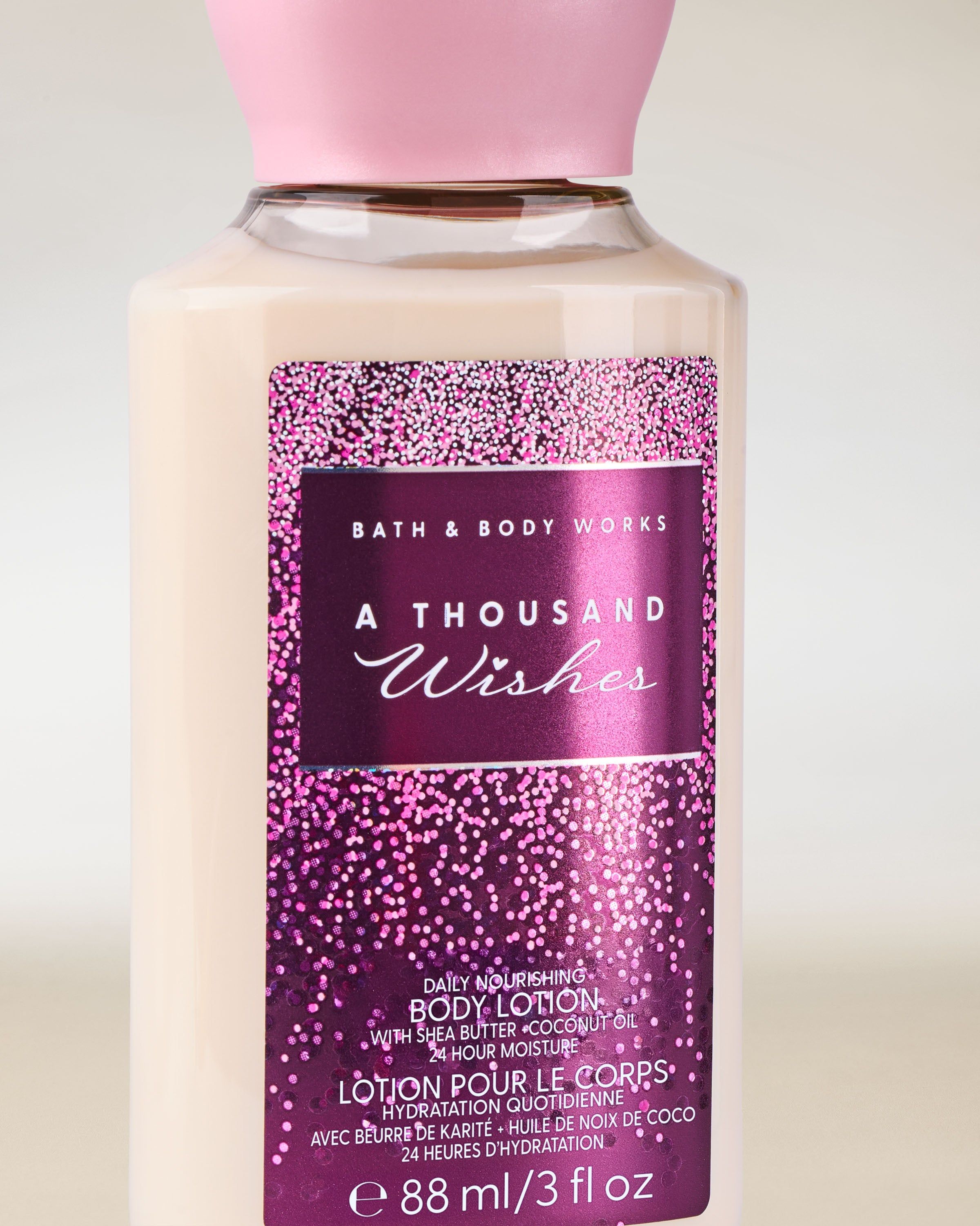 Mini balsam do ciała Bath & Body Works A Thousand Wishes z różowo‑fioletową, iskrzącą etykietą.