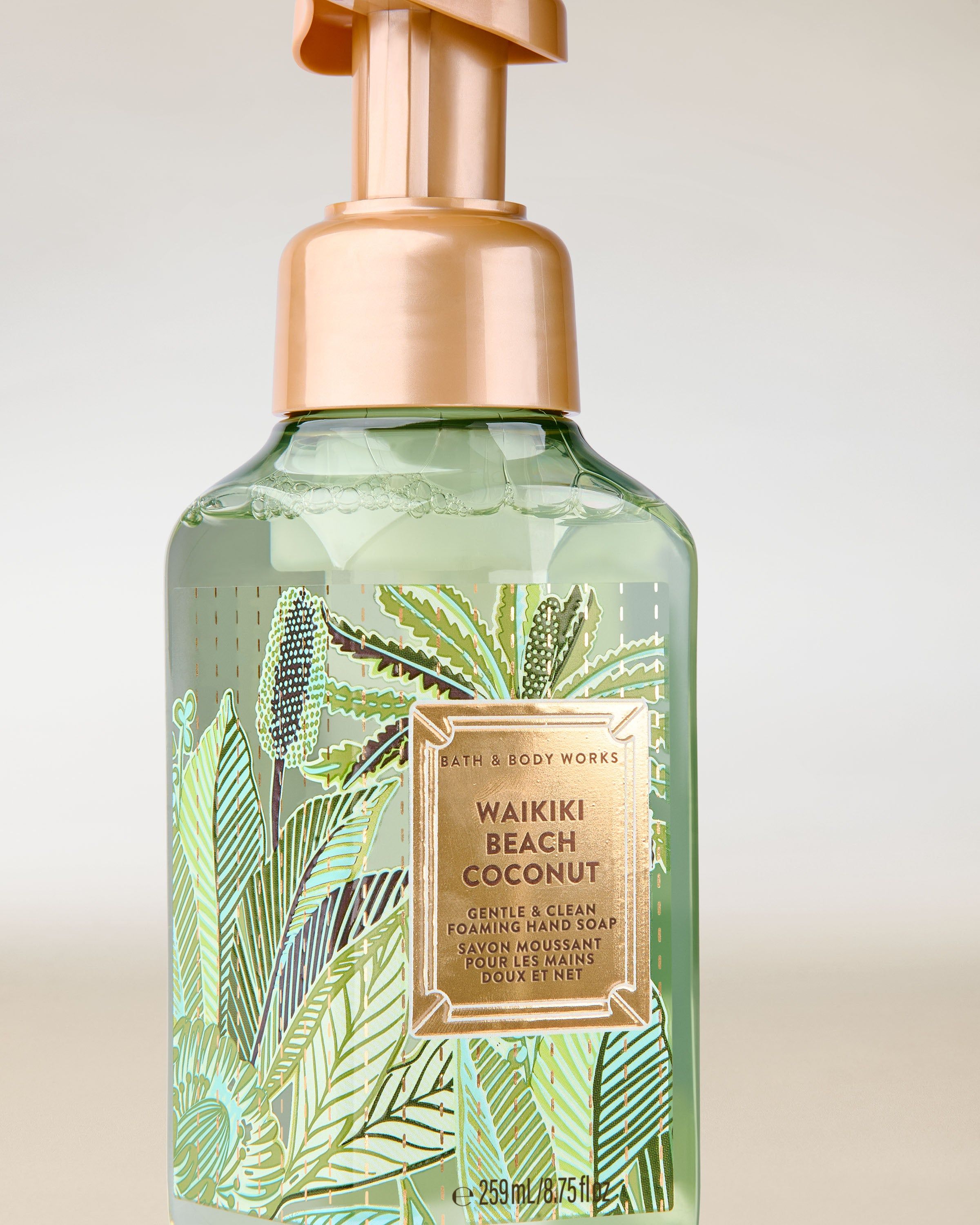 Waikiki Beach Coconut – zielone, transparentne mydło w piance ze złotą pompką i tropikalną etykietą w liście palm.