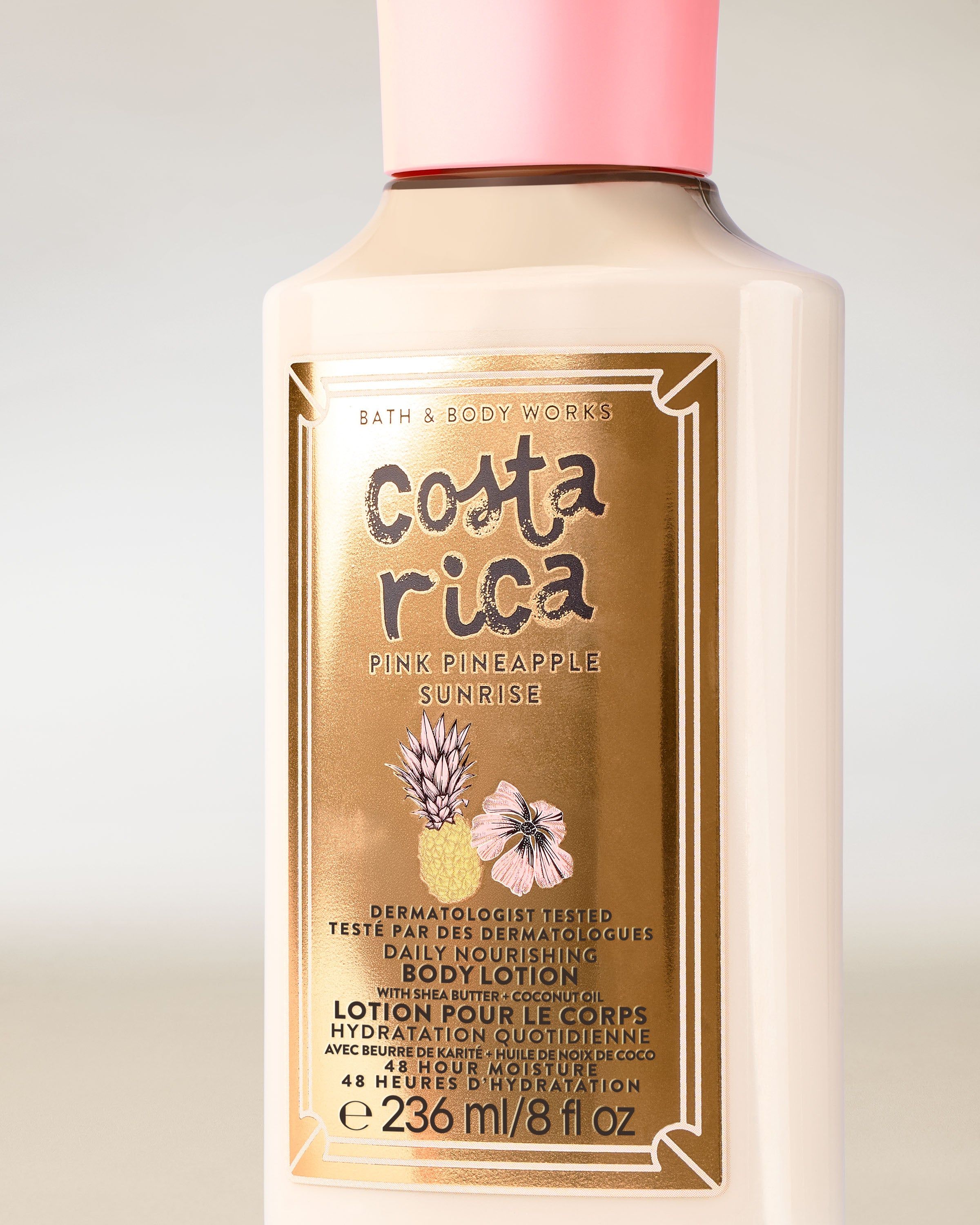 Lotion do ciała Costa Rica Pink Pineapple Sunrise w jasnej butelce z różową nakrętką i tropikalną etykietą.