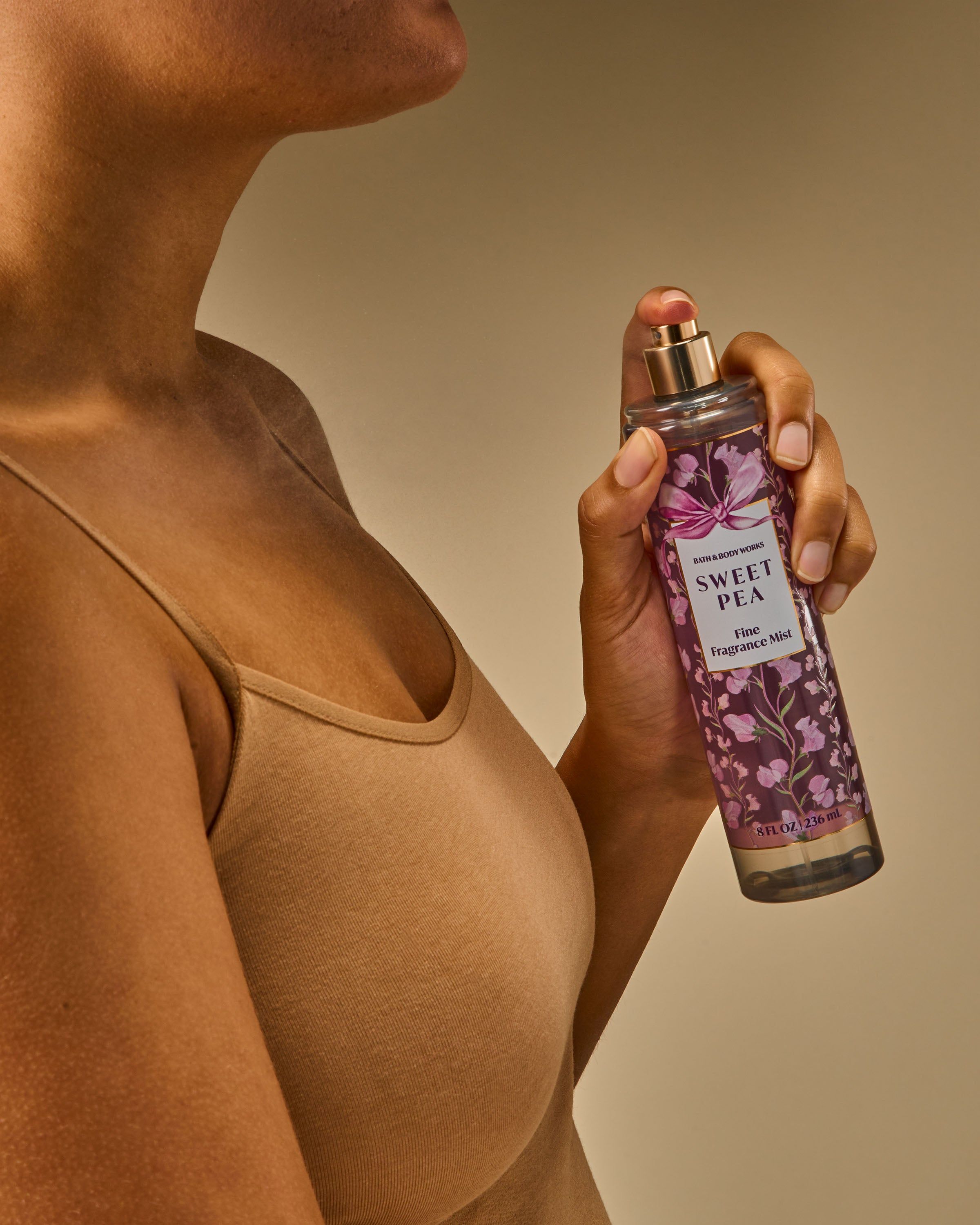 Mgiełka zapachowa Sweet Pea od Bath & Body Works w różowej butelce z atomizerem i kwiatową, dekoracyjną etykietą.