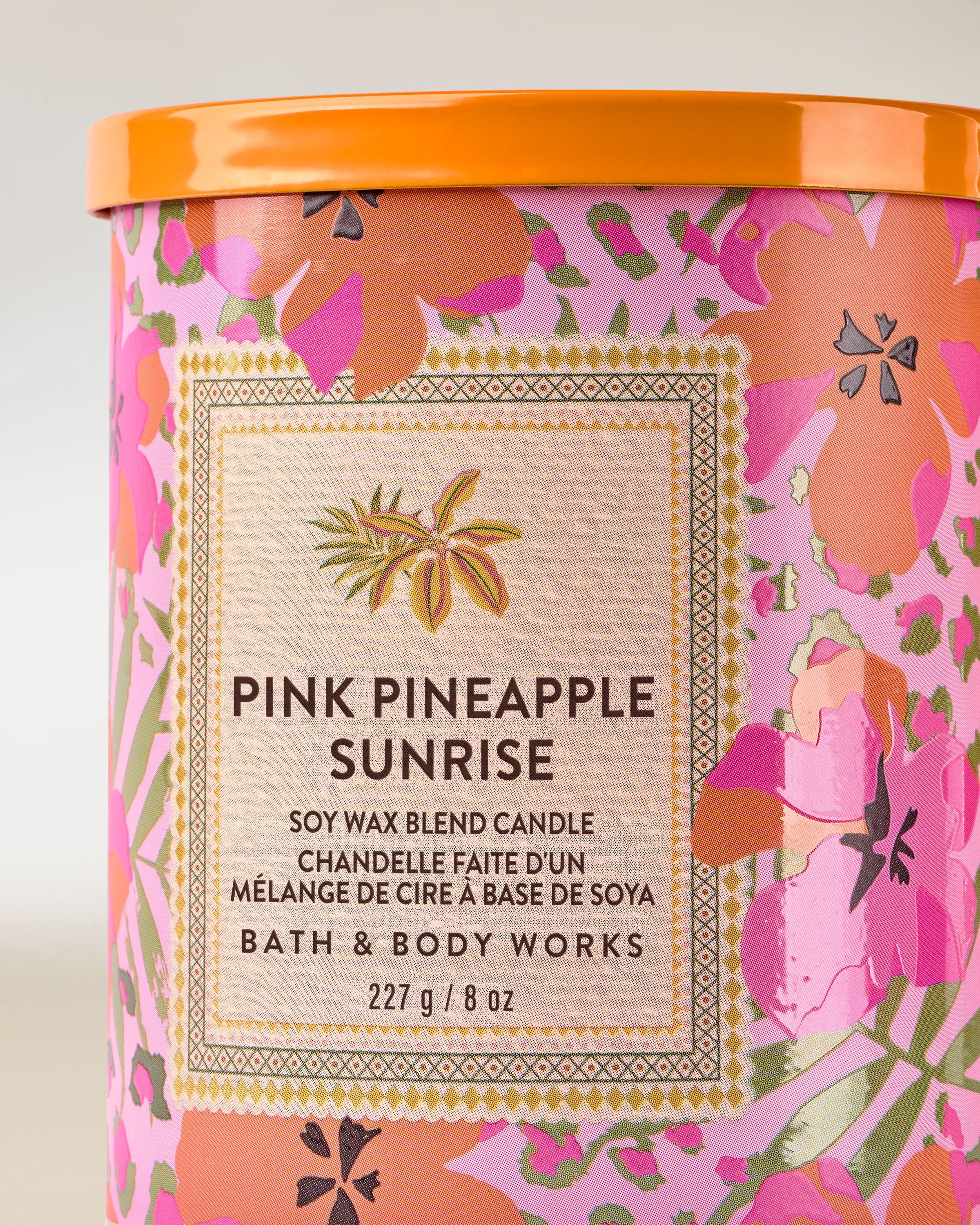 Świeca Pink Pineapple Sunrise z kolorową, tropikalną etykietą w hibiskusy i ananasa – letni, energetyczny design.
