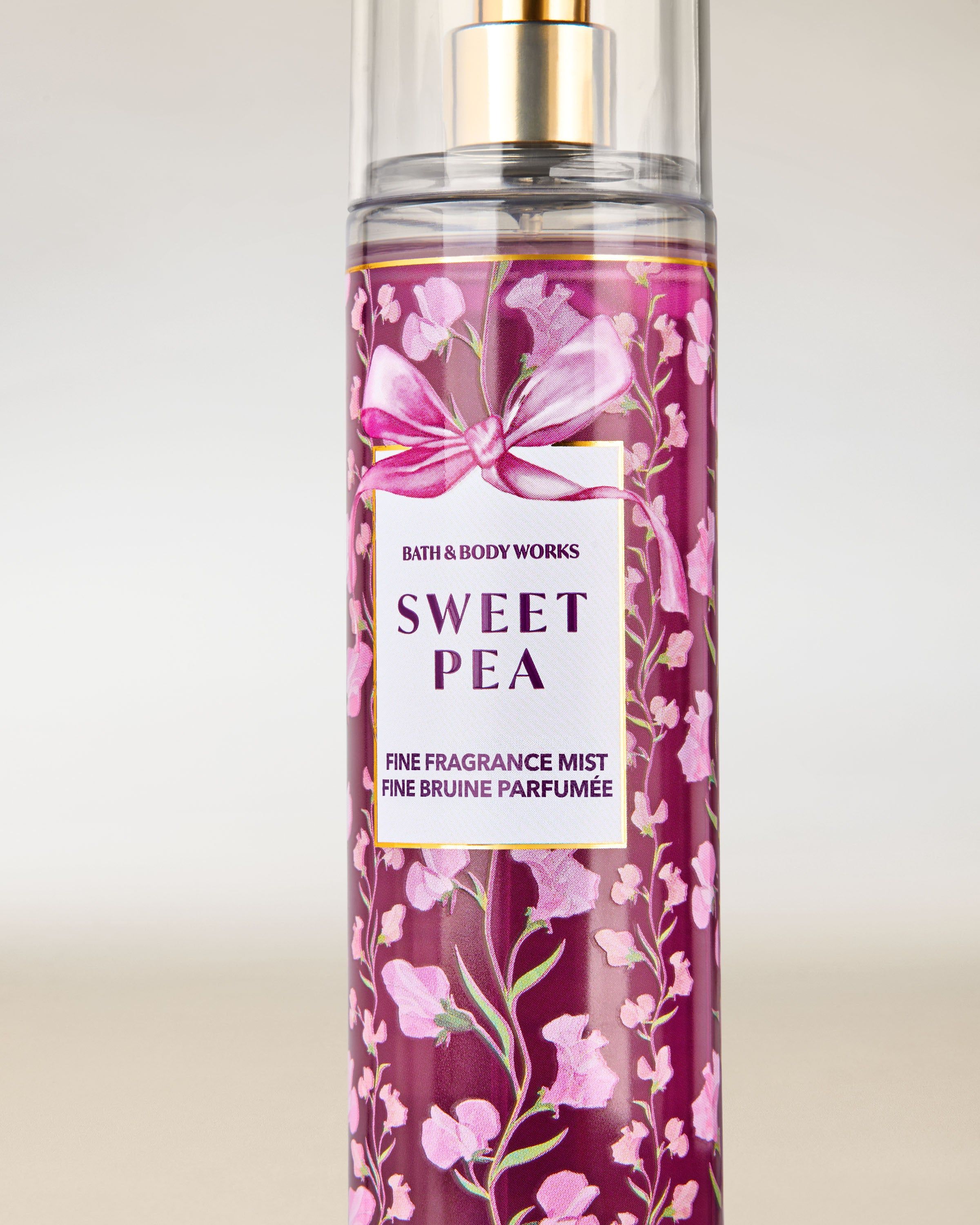 Mgiełka zapachowa Sweet Pea od Bath & Body Works w różowej butelce z atomizerem i kwiatową, dekoracyjną etykietą.