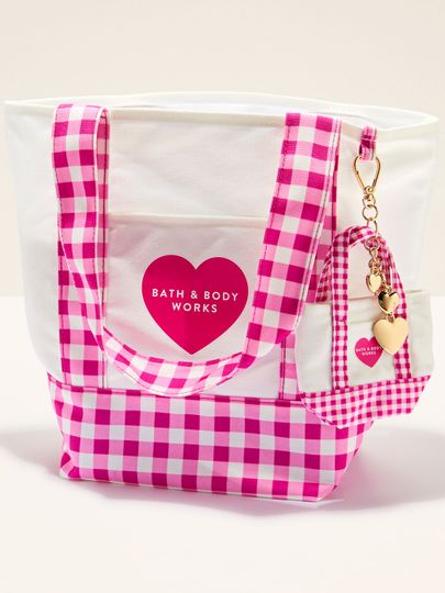 Torba Bath & Body Works w różowo‑białą kratkę gingham z uchwytami i ozdobnym brelokiem.
