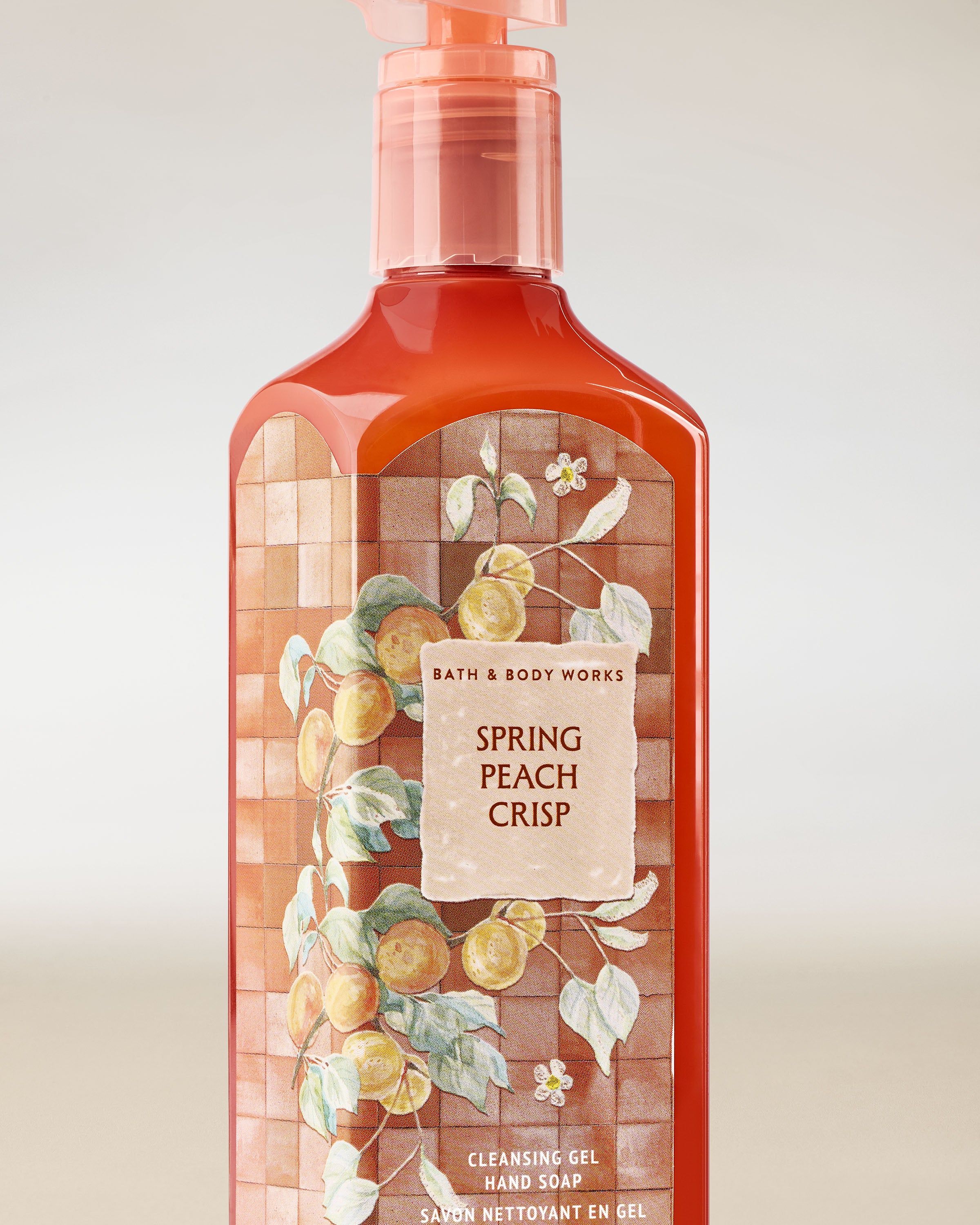 Żel do mycia rąk Bath & Body Works Spring Peach Crisp 236 ml w koralowej butelce z motywem brzoskwiń.