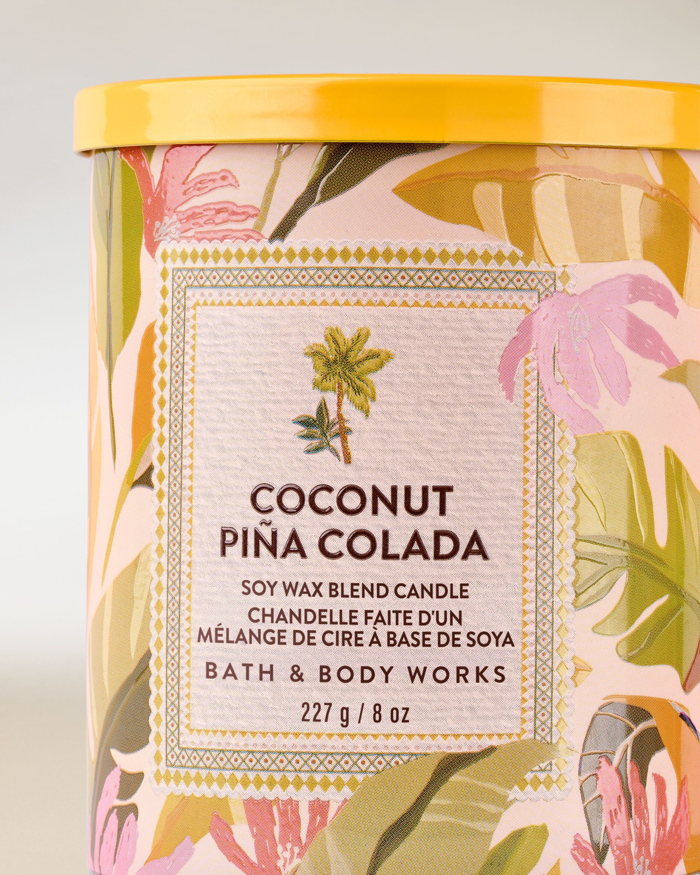 Świeca zapachowa Coconut Piña Colada od Bath & Body Works w szklanym słoju z kolorową, tropikalną etykietą.