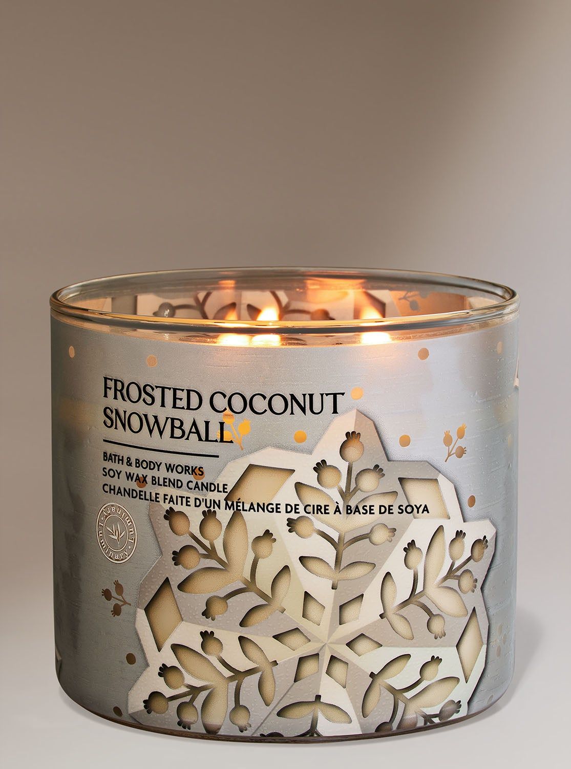 Lumânare "Frosted Coconut Snowball" într-un borcan cu un model decupat al unui fulg de zăpadă argintiu, Bath & Body Works.