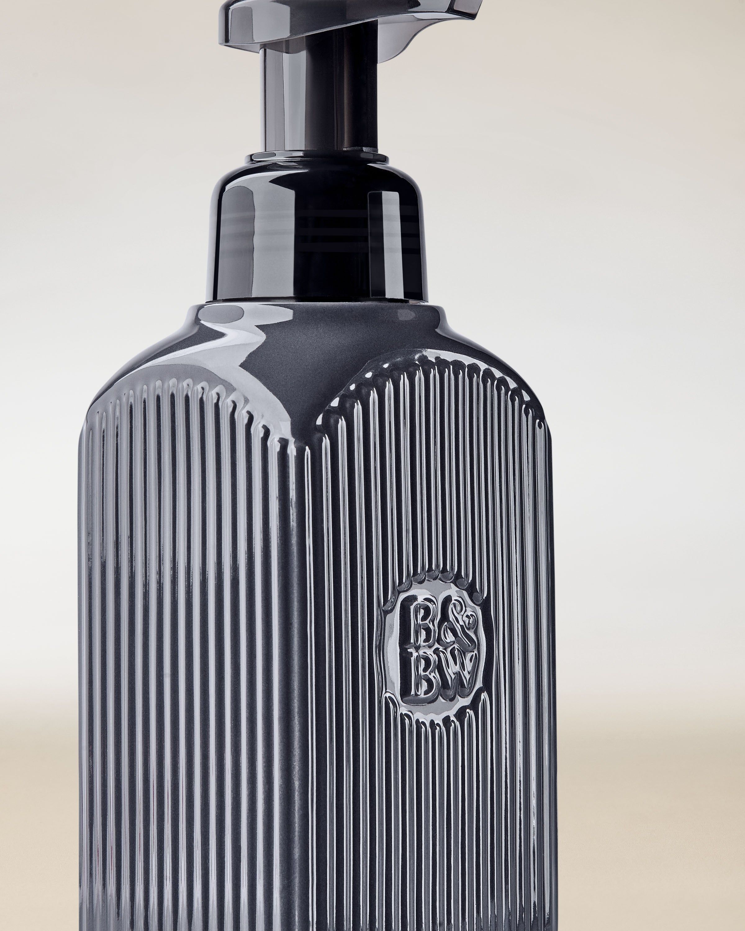 Dozownik na mydło Bath & Body Works w ciemnoszarym kolorze z pompką i tłoczonym logo.